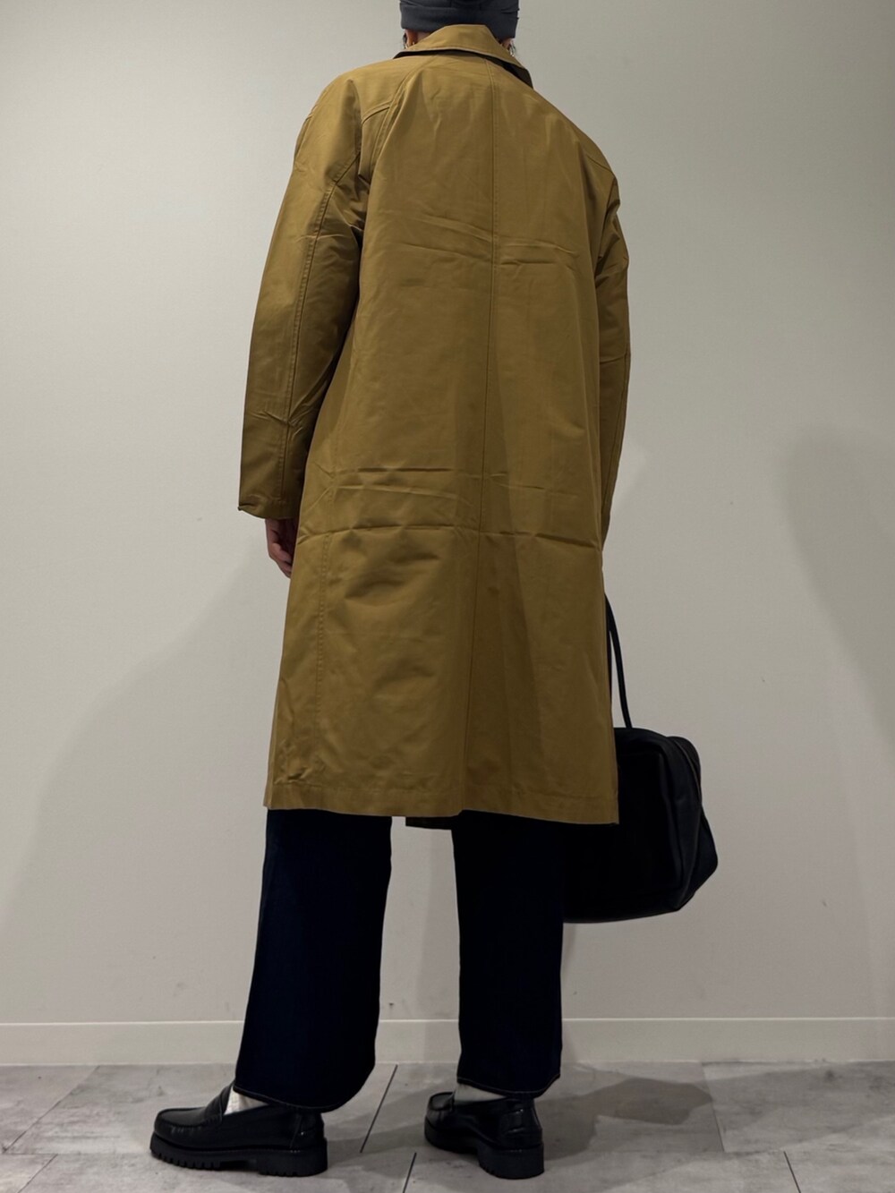 ブラック系のボストンバッグ、ベージュ系のダウンジャケット/コート、ブルー系のデニムパンツを着用したレディースの冬コーディネートの5枚目の写真