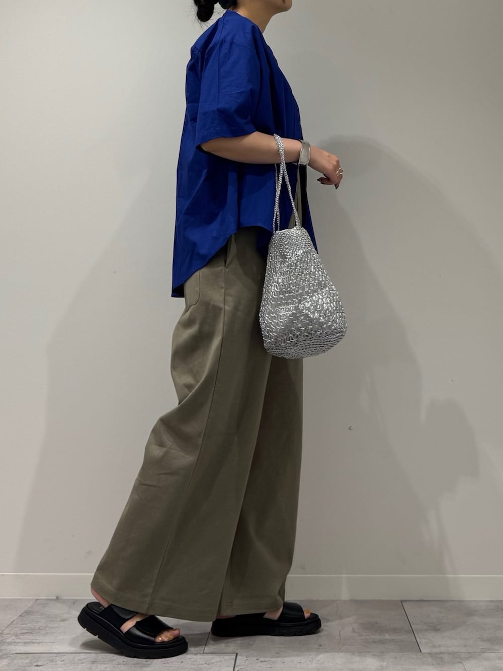 シルバー系のかごバッグ、グリーン系のサロペット/オーバーオール、ブルー系のシャツ/ブラウスを着用したレディースの夏コーディネートの2枚目の写真