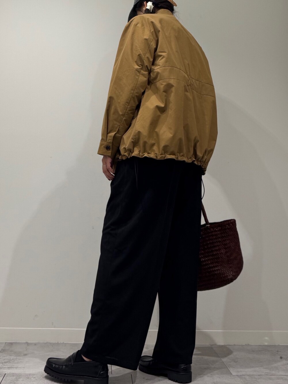 ブラウン系のトートバッグ、ブラック系のサロペット/オーバーオール、ブラック系のローファーを着用したレディースの秋コーディネートの4枚目の写真