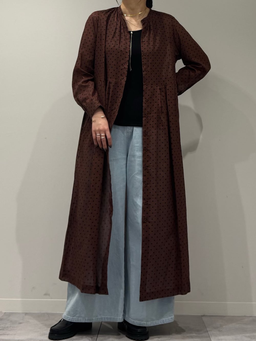 ブラウン系のワンピース、ブルー系のデニムパンツ、ブラック系のローファーを着用したレディースの春コーディネートの8枚目の写真