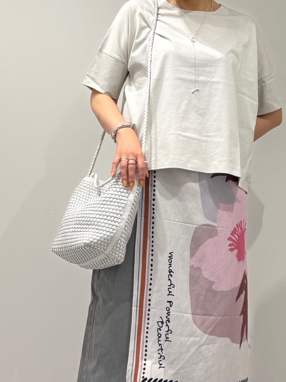 ホワイト系のトートバッグ、ブラック系のサンダル、グレー系のデニムパンツを着用したレディースの春コーディネートの8枚目の写真