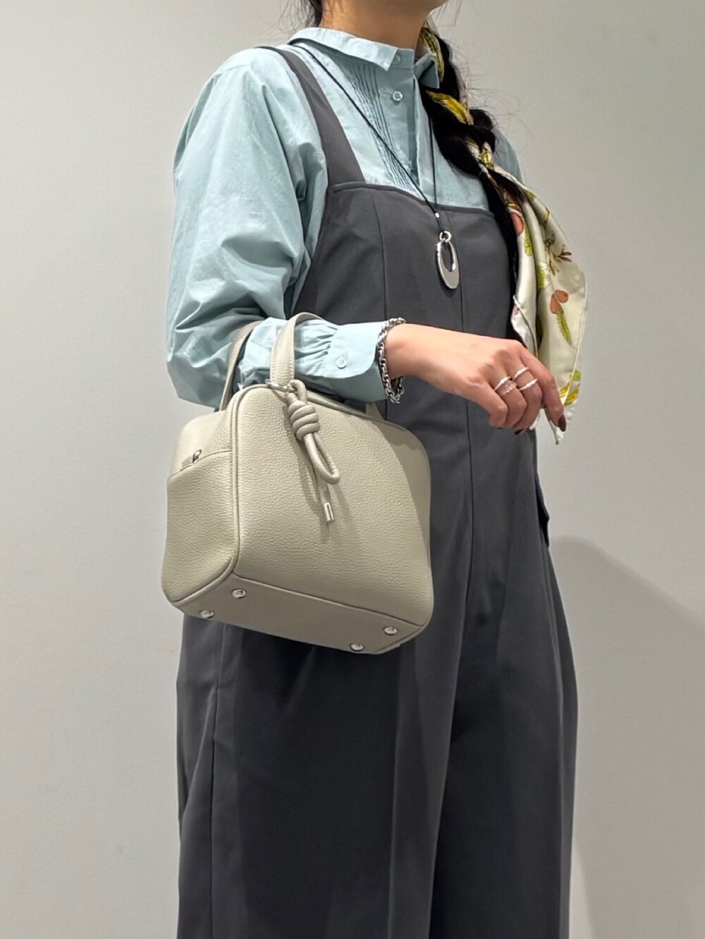 ブラック系のローファー、グレー系のサロペット/オーバーオール、グレー系のボストンバッグを着用したレディースの秋コーディネートの8枚目の写真