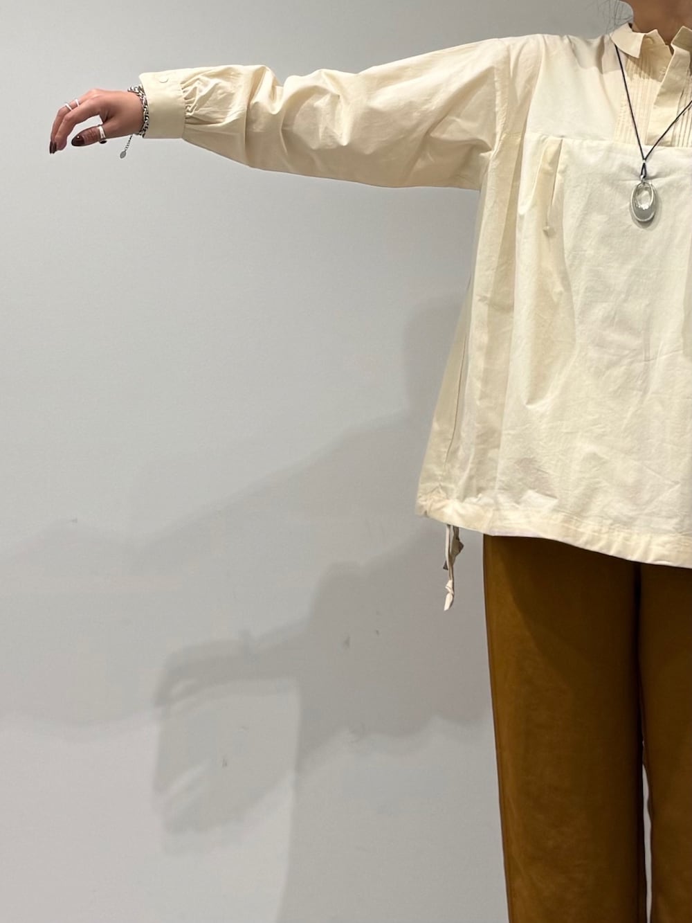 グレー系のボストンバッグ、ホワイト系のシャツ/ブラウス、ブラウン系のその他パンツを着用したレディースの秋コーディネートの6枚目の写真