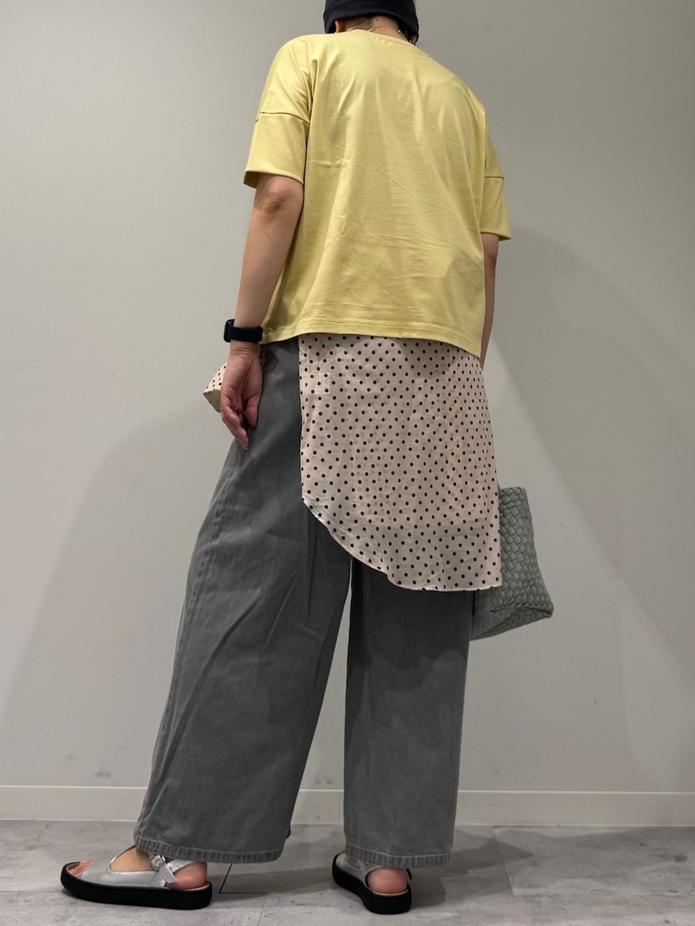 グレー系のトートバッグ、グレー系のデニムパンツ、ホワイト系のシャツ/ブラウスを着用したレディースの春コーディネートの4枚目の写真