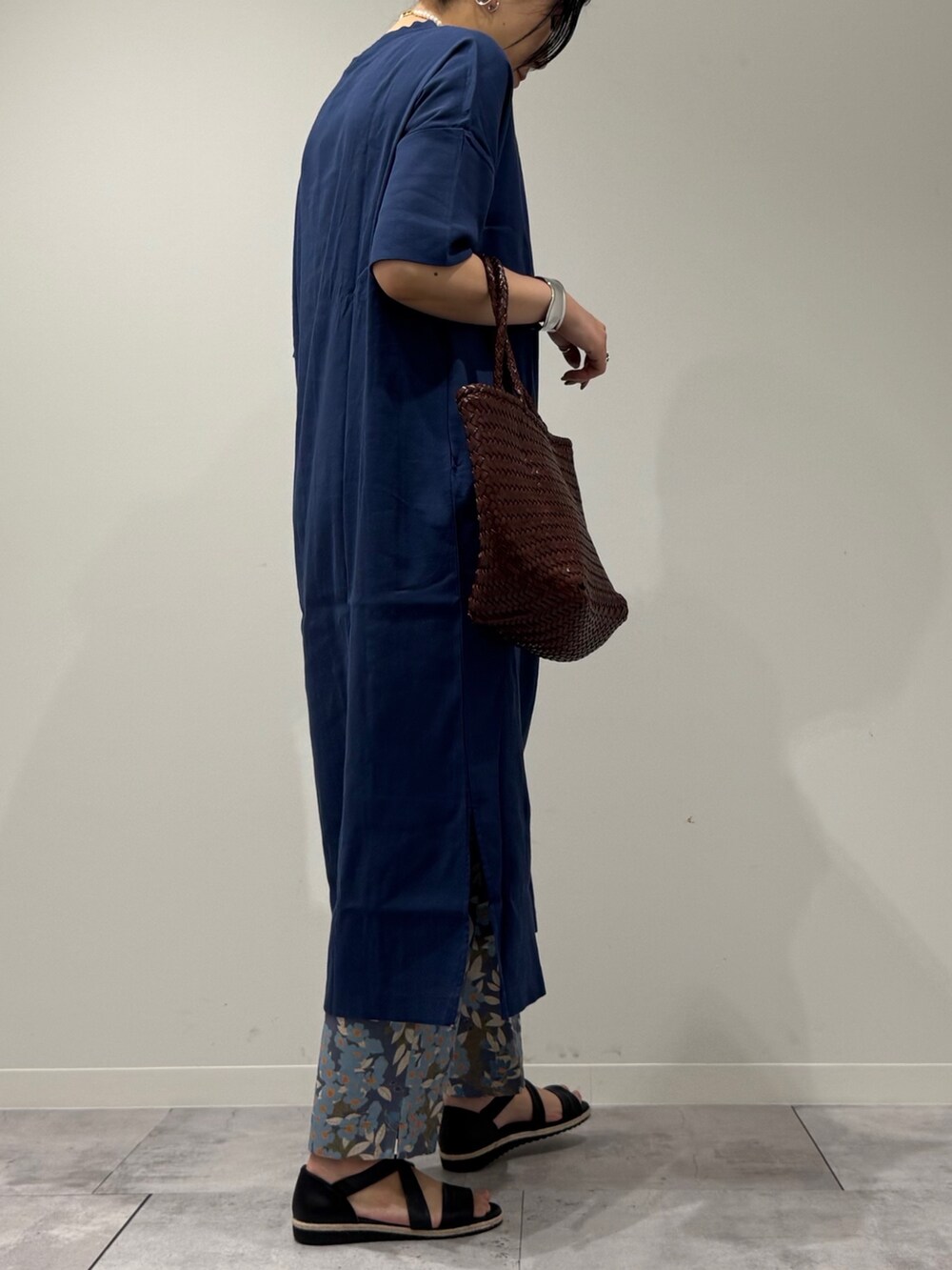 ブラウン系のトートバッグ、ブルー系のその他パンツ、ブラック系のサンダルを着用したレディースの春コーディネートの3枚目の写真