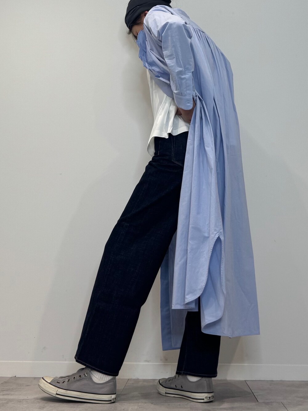 ブルー系のシャツワンピース、シルバー系のかごバッグ、ブルー系のデニムパンツを着用したレディースの春コーディネートの5枚目の写真