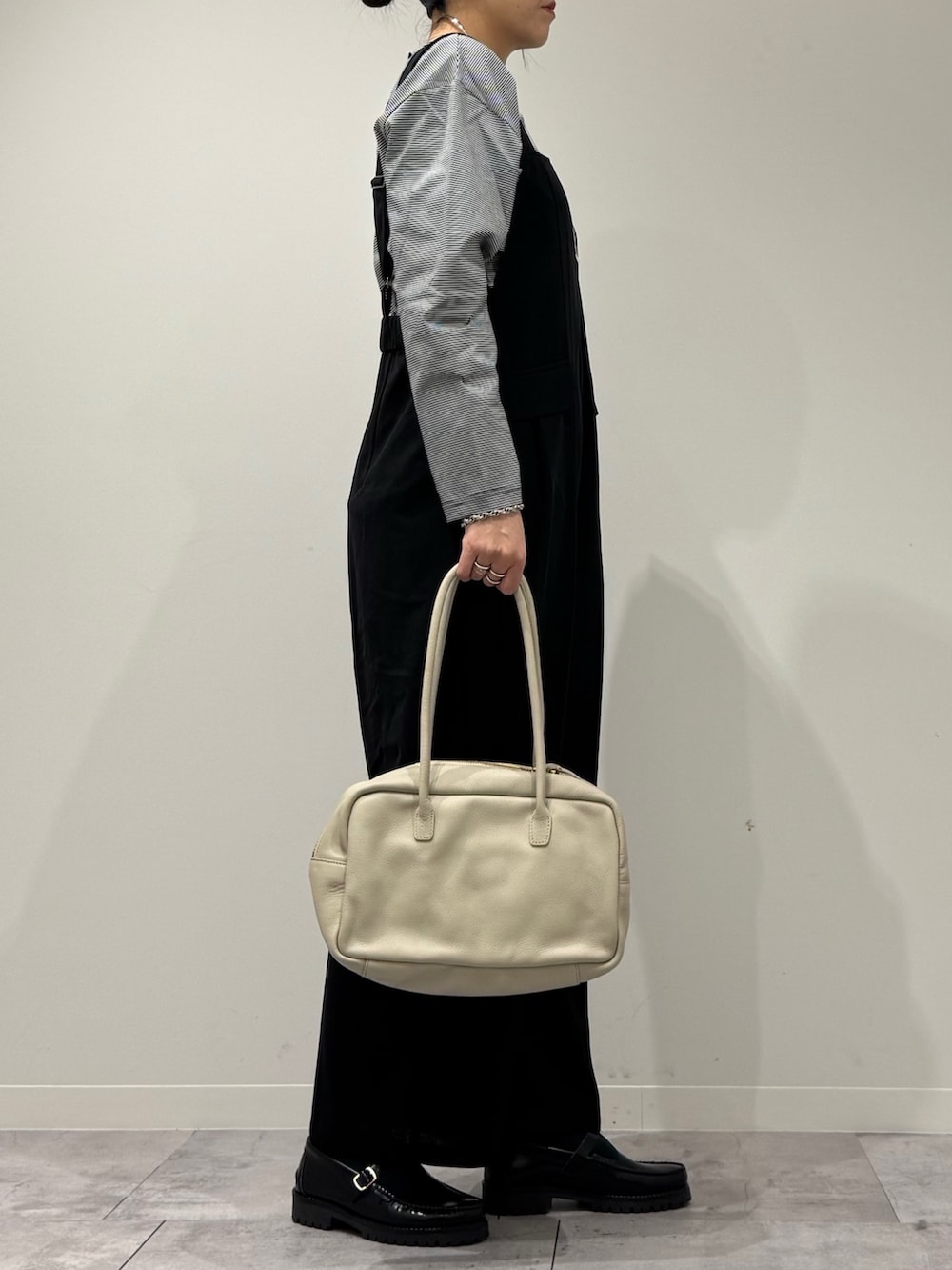 ベージュ系のボストンバッグ、ブラック系のサロペット/オーバーオール、ブラック系のローファーを着用したレディースの春コーディネートの3枚目の写真