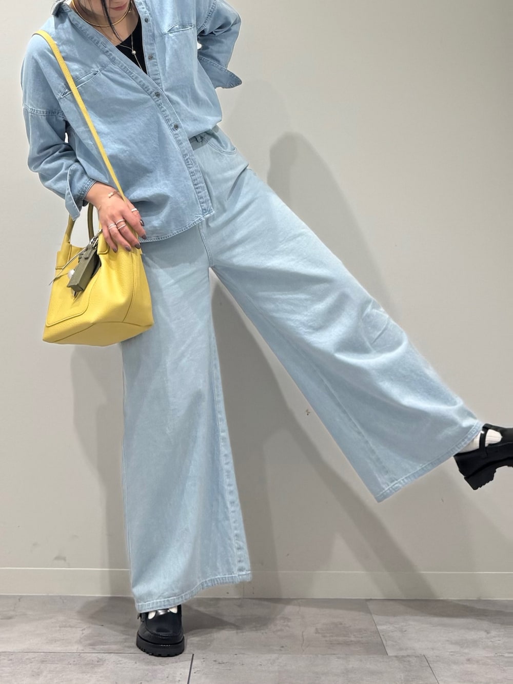 イエロー系のショルダーバッグ、ブルー系のデニムパンツ、ブラック系のローファーを着用したレディースの春コーディネートの8枚目の写真