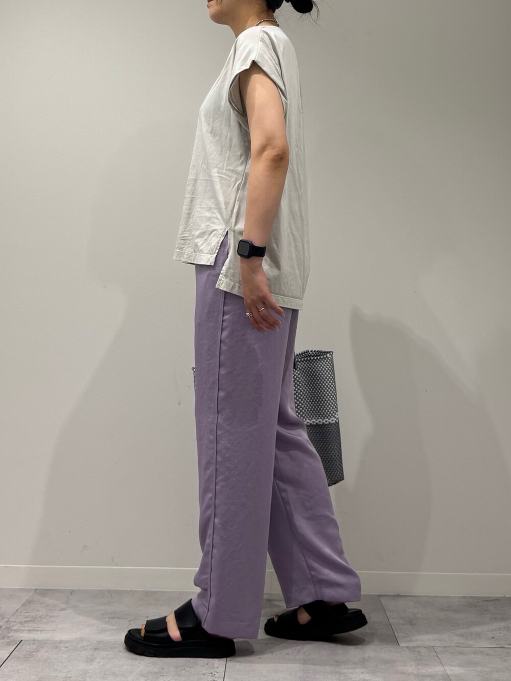 グレー系のTシャツ/カットソー、シルバー系のかごバッグ、ブラック系のサンダルを着用したレディースの夏コーディネートの5枚目の写真