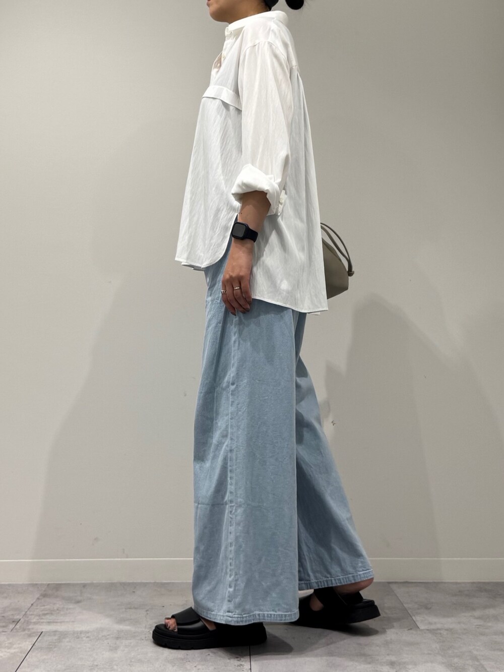 ベージュ系のショルダーバッグ、ブルー系のデニムパンツ、ブラック系のサンダルを着用したレディースの秋コーディネートの6枚目の写真