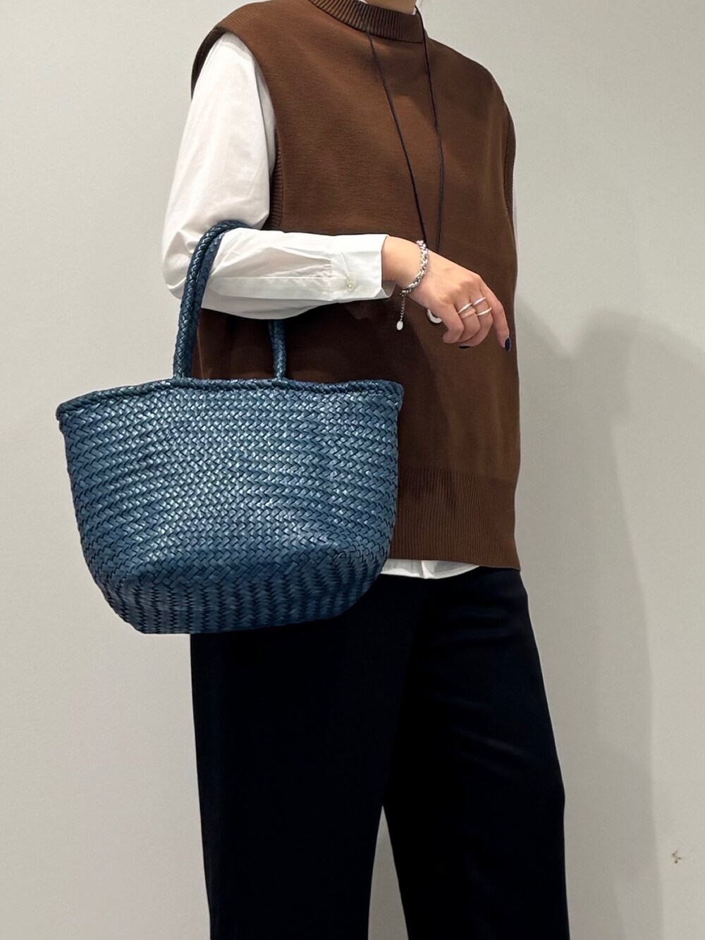 ブルー系のトートバッグ、ブラック系のその他パンツ、ホワイト系のシャツ/ブラウスを着用したレディースの秋コーディネートの8枚目の写真