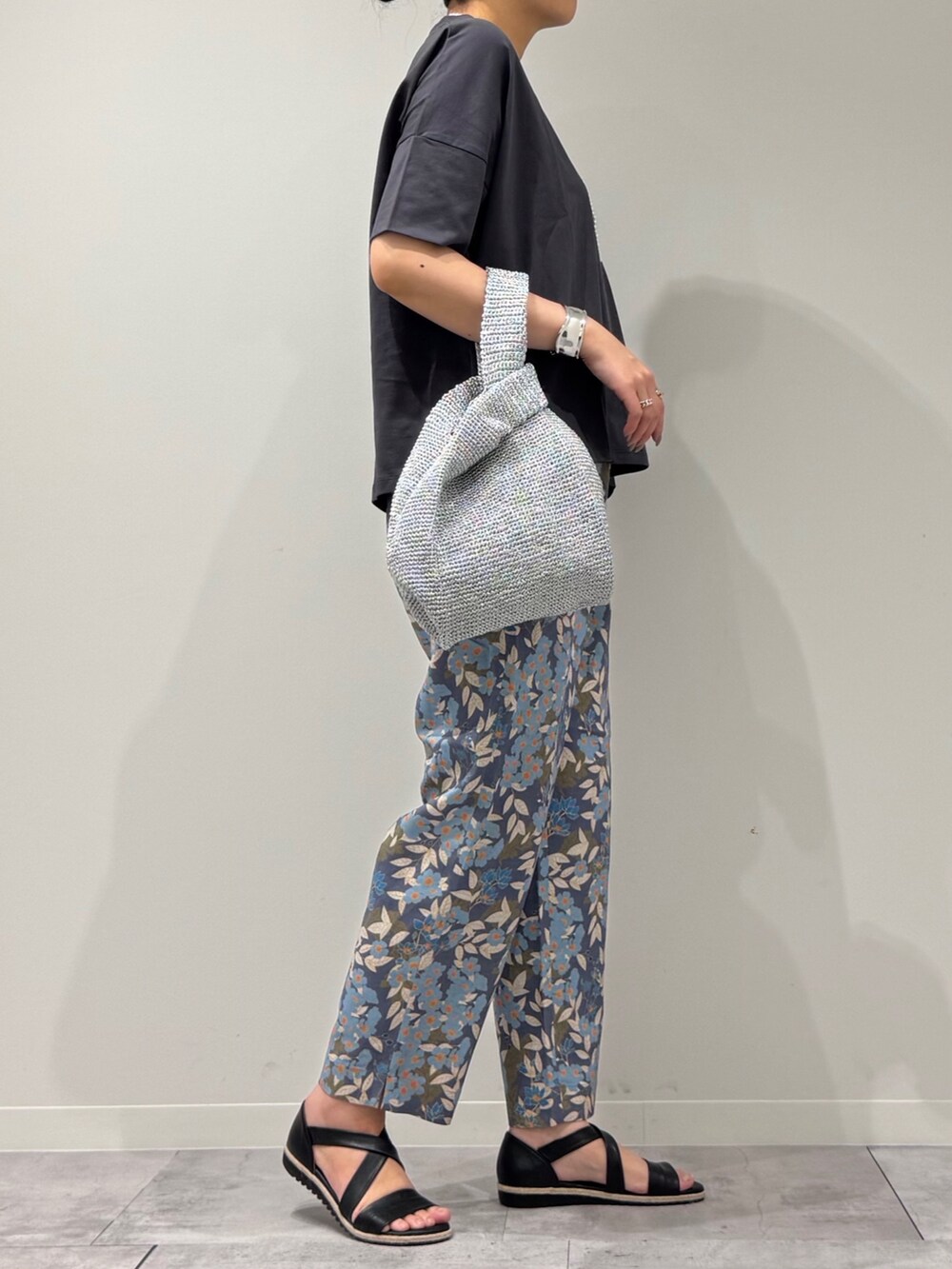 シルバー系のかごバッグ、ブルー系のその他パンツ、グレー系のTシャツ/カットソーを着用したレディースの春コーディネートの2枚目の写真