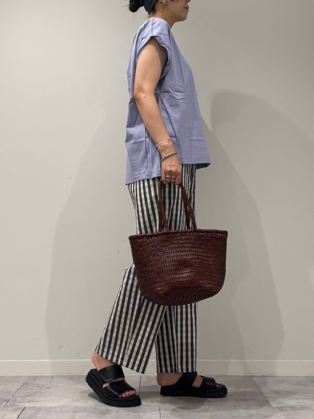 ブラウン系のトートバッグ、ブラック系のその他パンツ、ブラック系のサンダルを着用したレディースの秋コーディネートの2枚目の写真