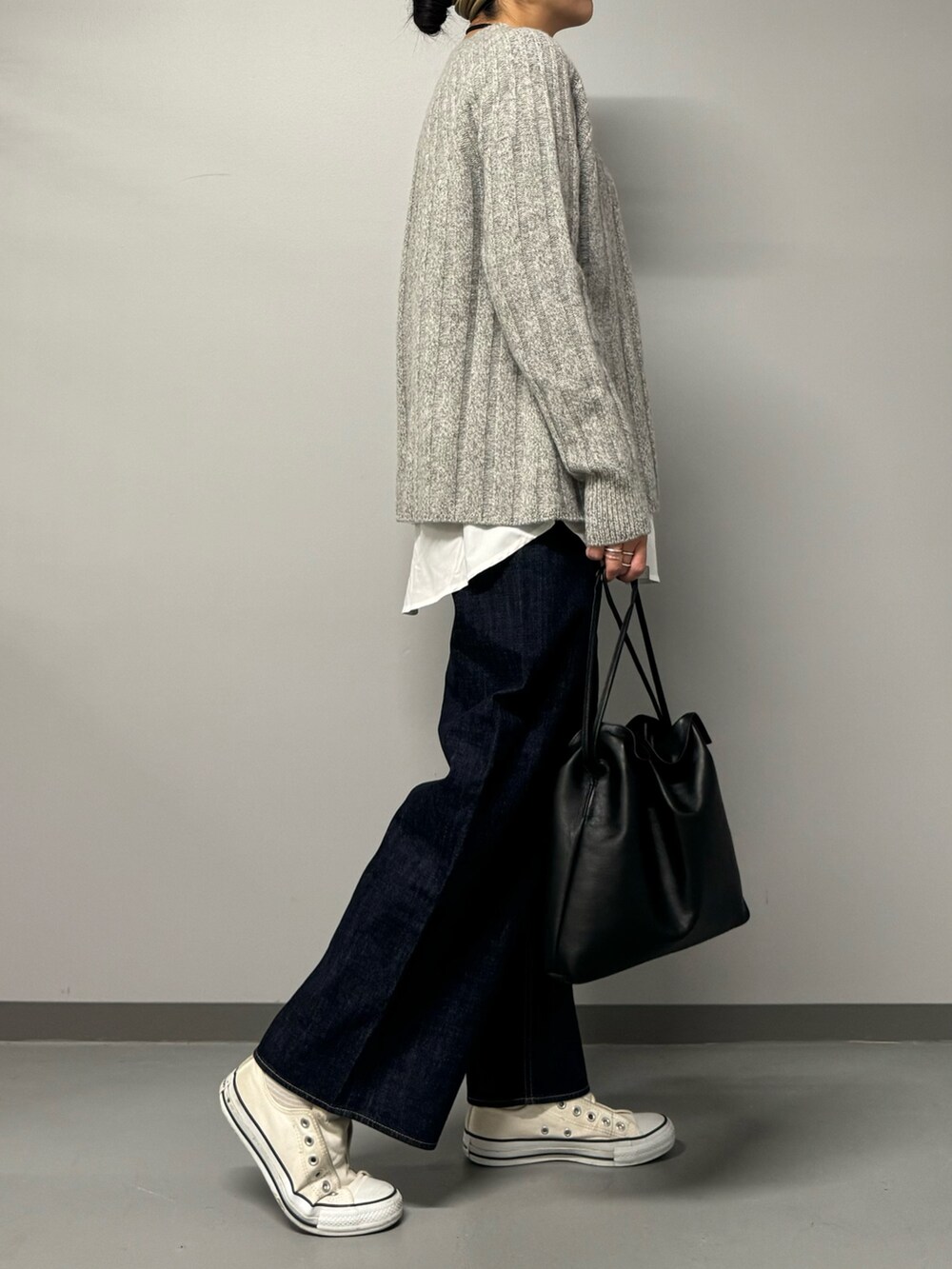 ブルー系のデニムパンツ、ブラック系のショルダーバッグ、グレー系のニット/セーターを着用したレディースの秋コーディネートの6枚目の写真