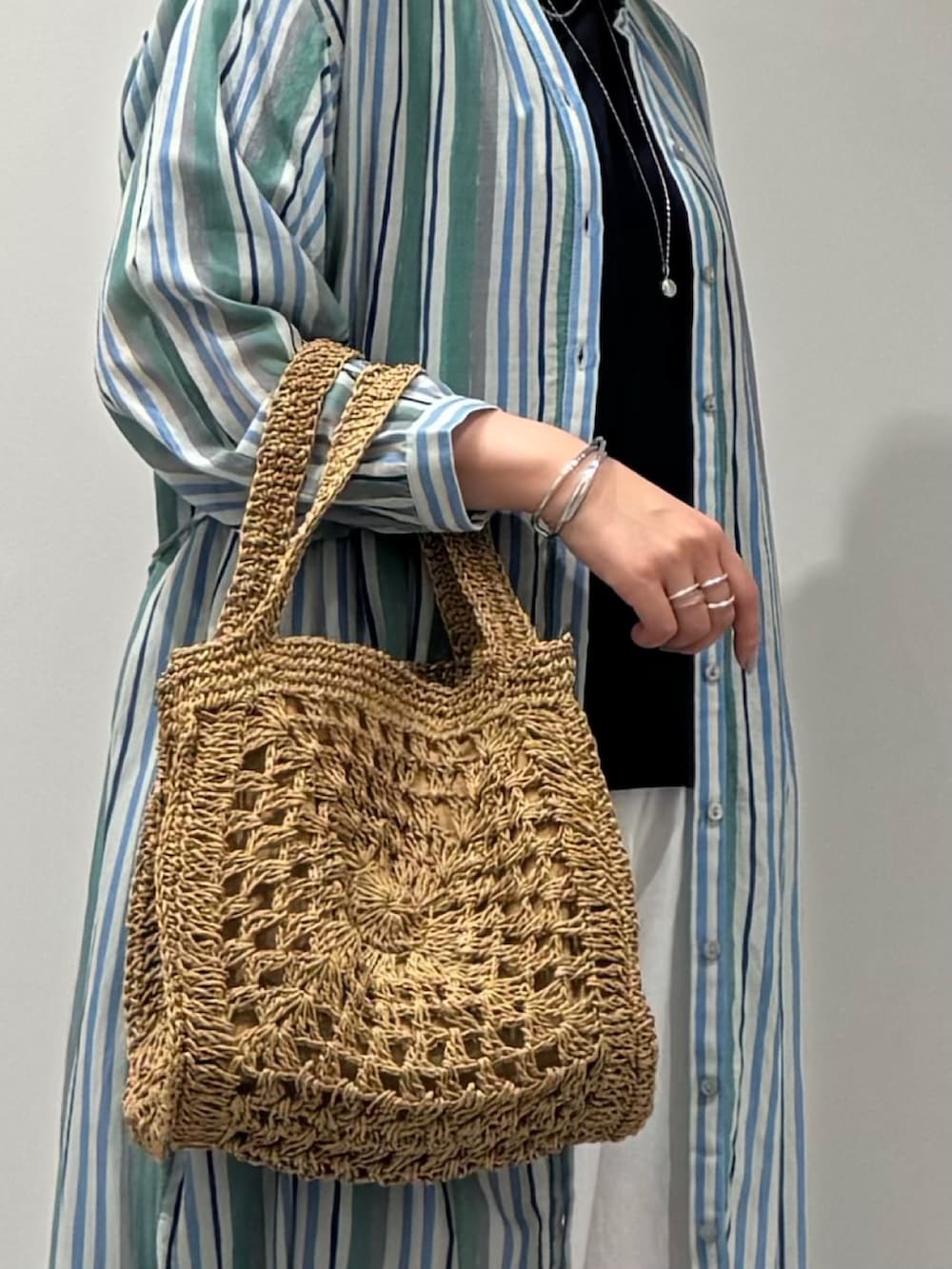 ベージュ系のかごバッグ、ホワイト系のその他パンツ、ブラック系のサンダルを着用したレディースの夏コーディネートの8枚目の写真