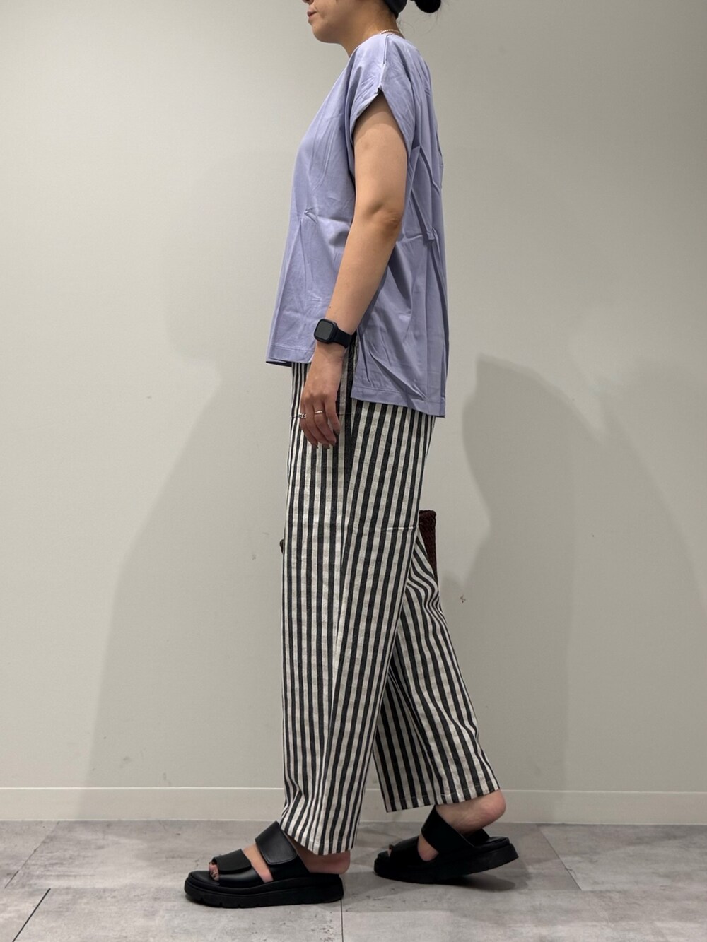 ブラウン系のトートバッグ、ブラック系のその他パンツ、ブラック系のサンダルを着用したレディースの秋コーディネートの5枚目の写真