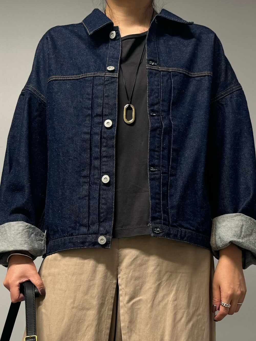 ブラック系のショルダーバッグ、グレー系のTシャツ/カットソー、ゴールド系のネックレスを着用したレディースの秋コーディネートの6枚目の写真