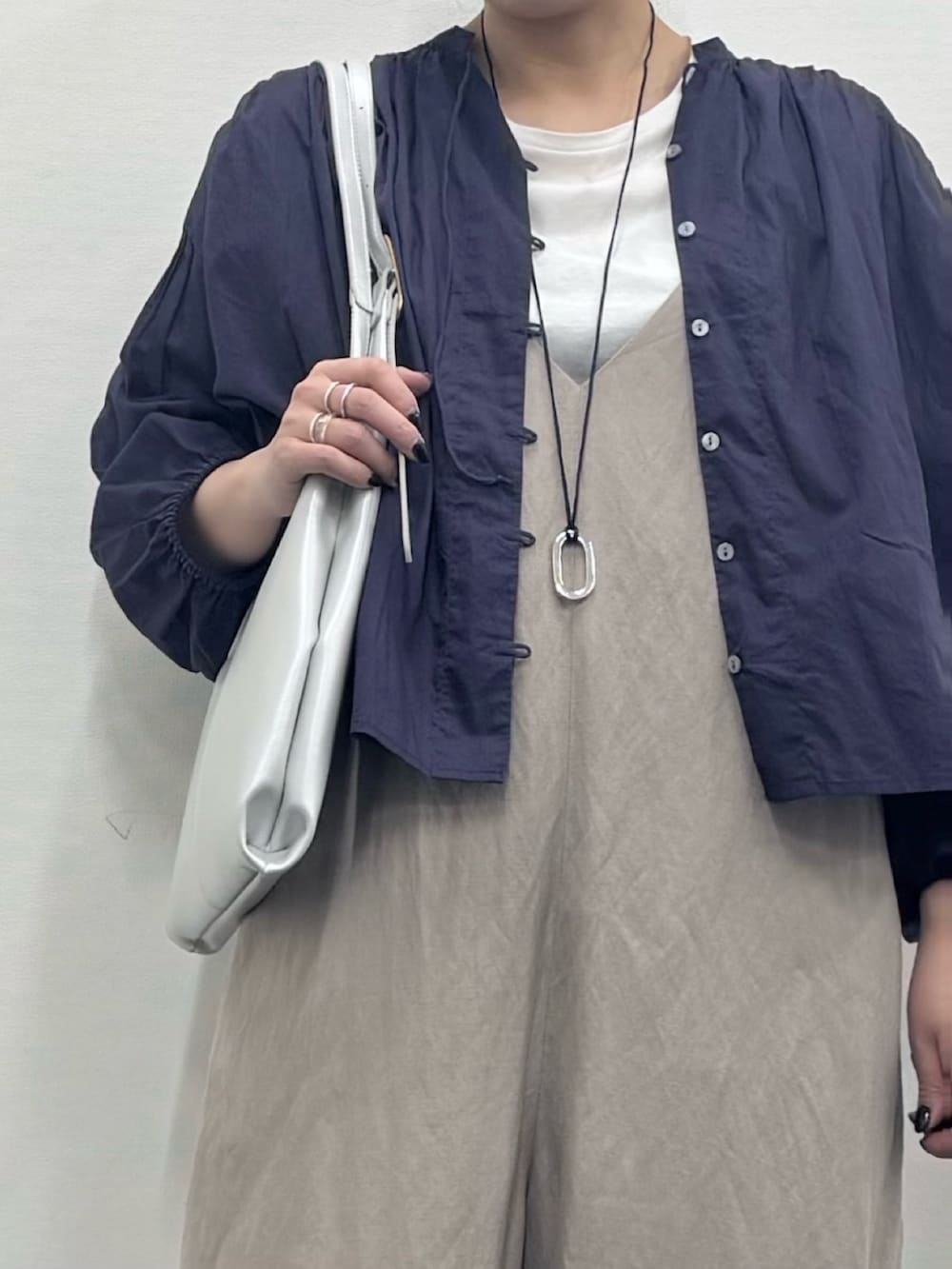 シルバー系のトートバッグ、ベージュ系のサロペット/オーバーオール、ホワイト系のTシャツ/カットソーを着用したレディースの春コーディネートの9枚目の写真