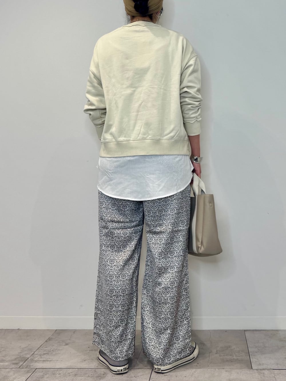 ホワイト系のスウェット、ベージュ系のトートバッグ、ブラック系のその他パンツを着用したレディースの秋コーディネートの4枚目の写真