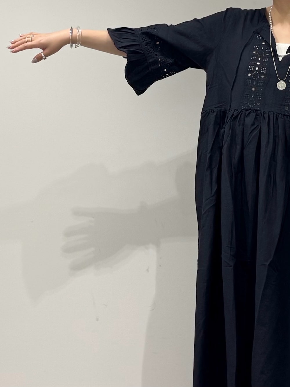 ブラック系のワンピース、シルバー系のかごバッグ、ブラック系のサンダルを着用したレディースの秋コーディネートの7枚目の写真