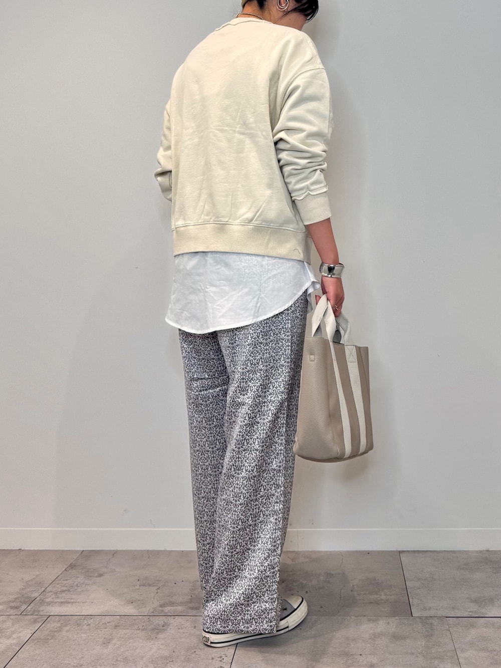 ホワイト系のスウェット、ベージュ系のトートバッグ、ブラック系のその他パンツを着用したレディースの秋コーディネートの3枚目の写真