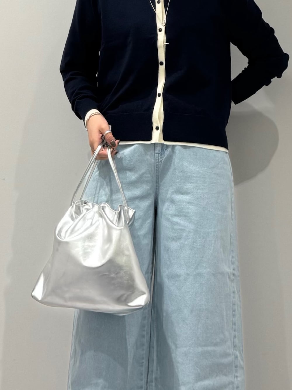 シルバー系のショルダーバッグ、ブルー系のデニムパンツ、ブルー系のカーディガン/ボレロを着用したレディースの春コーディネートの9枚目の写真