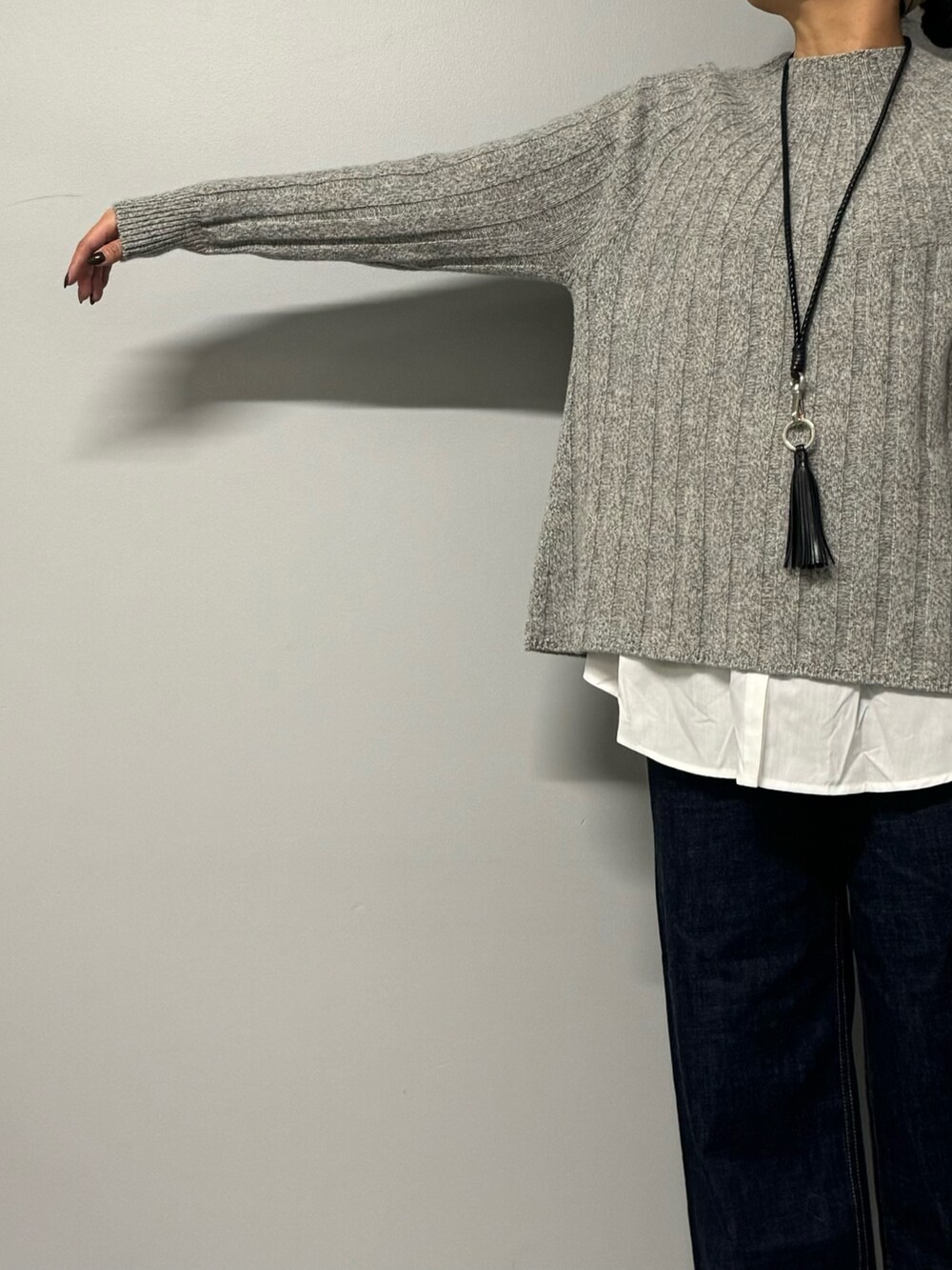 ブルー系のデニムパンツ、ブラック系のショルダーバッグ、グレー系のニット/セーターを着用したレディースの秋コーディネートの5枚目の写真