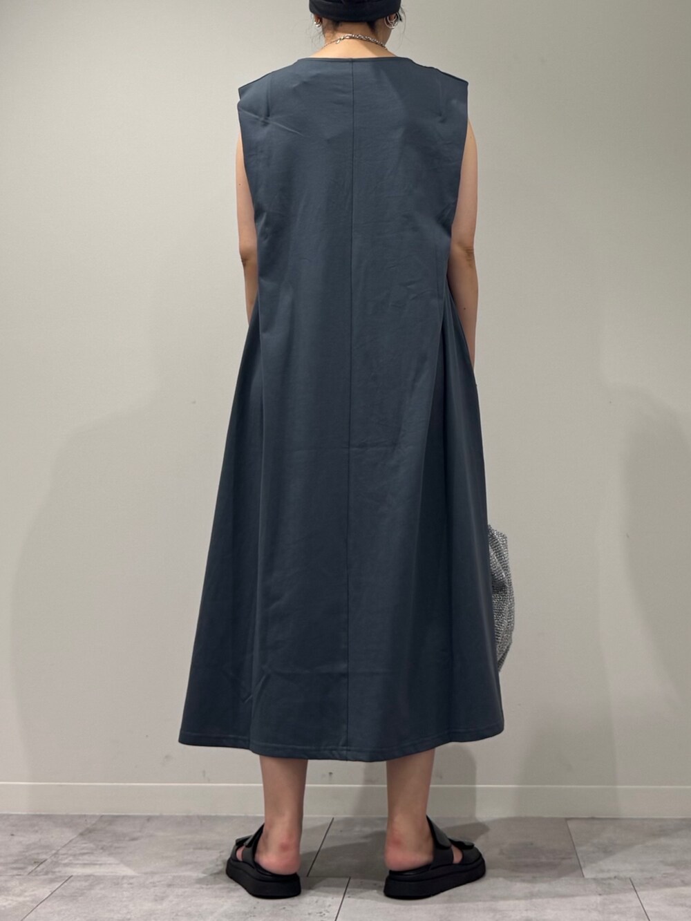 シルバー系のかごバッグ、ブラック系のサンダル、ブルー系のワンピースを着用したレディースの夏コーディネートの4枚目の写真