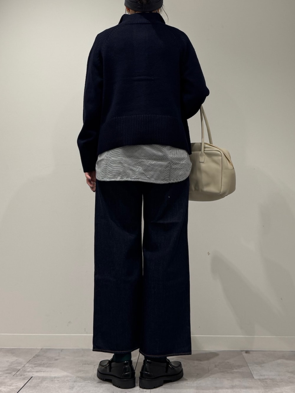 ベージュ系のボストンバッグ、ブルー系のデニムパンツ、ブラック系のローファーを着用したレディースの冬コーディネートの3枚目の写真