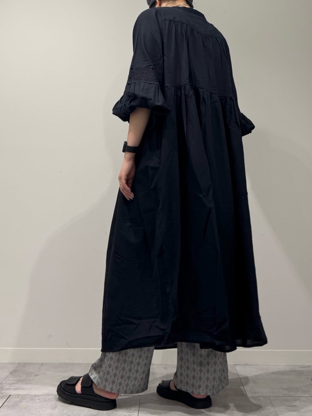 ブラック系のワンピース、シルバー系のかごバッグ、ブラック系のサンダルを着用したレディースの秋コーディネートの5枚目の写真