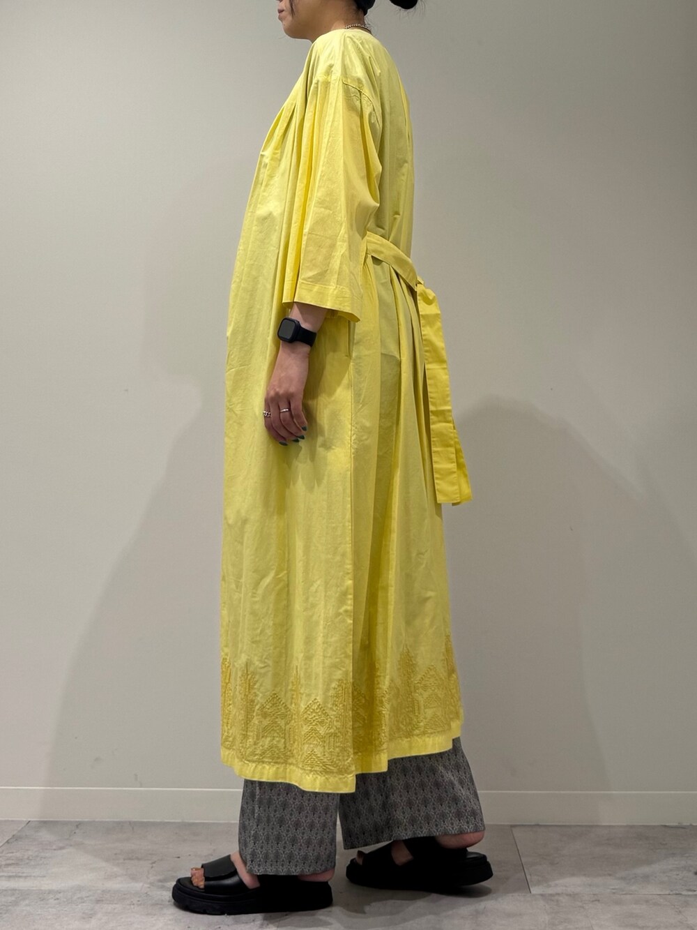 ホワイト系のかごバッグ、イエロー系のワンピース、ベージュ系のその他パンツを着用したレディースの夏コーディネートの6枚目の写真