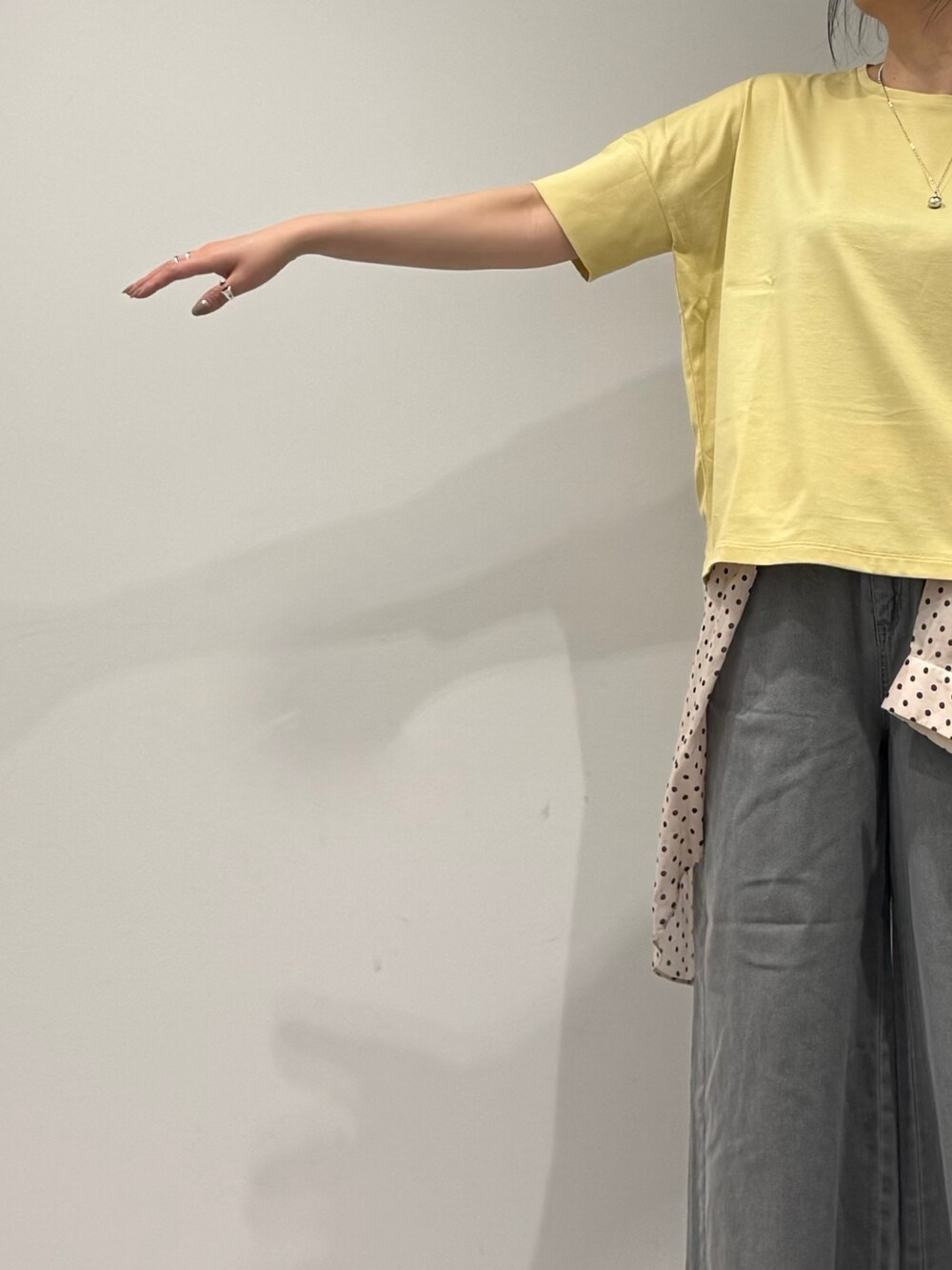 グレー系のトートバッグ、グレー系のデニムパンツ、ホワイト系のシャツ/ブラウスを着用したレディースの春コーディネートの6枚目の写真