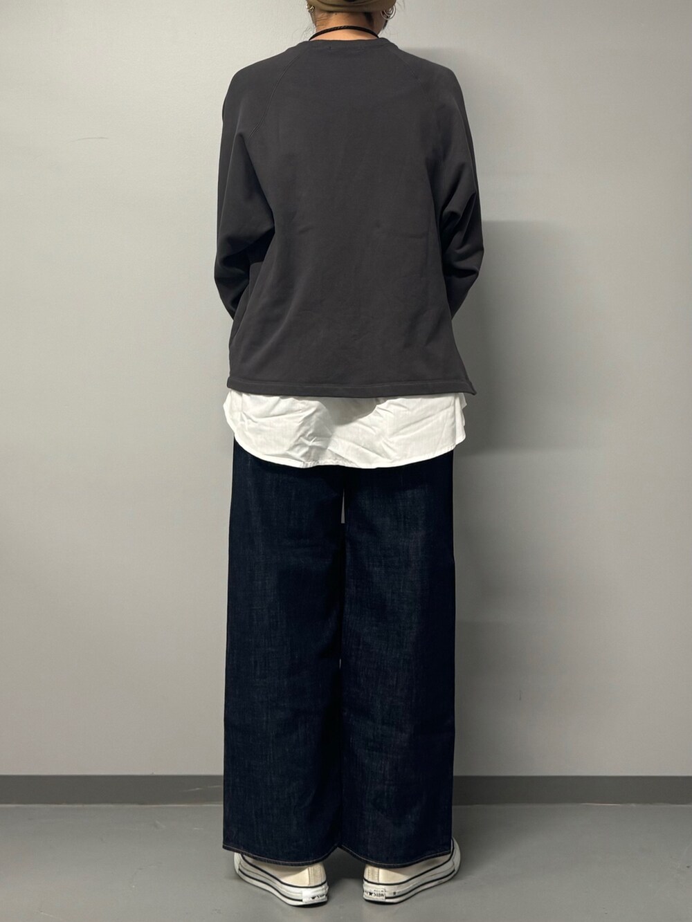 グレー系のスウェット、ブルー系のデニムパンツ、ブラック系のボストンバッグを着用したレディースの秋コーディネートの2枚目の写真