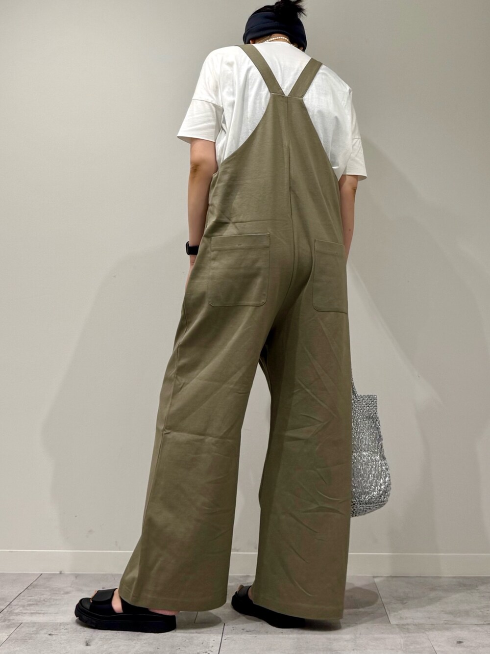 シルバー系のかごバッグ、ブラック系のサンダル、ホワイト系のTシャツ/カットソーを着用したレディースの夏コーディネートの5枚目の写真