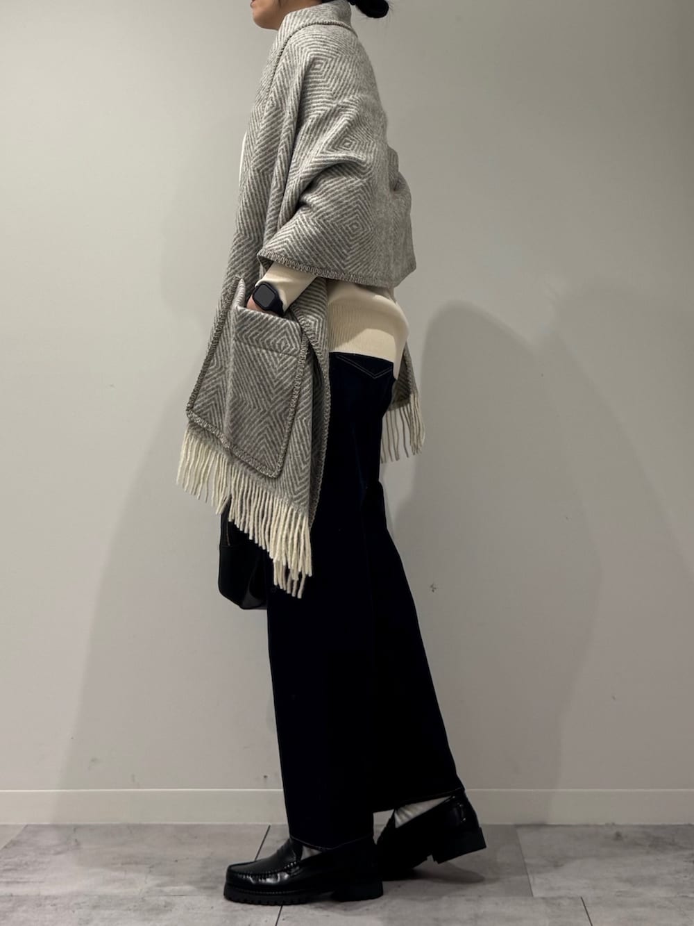 ブラック系のボストンバッグ、ブルー系のデニムパンツ、ブラック系のローファーを着用したレディースの冬コーディネートの5枚目の写真