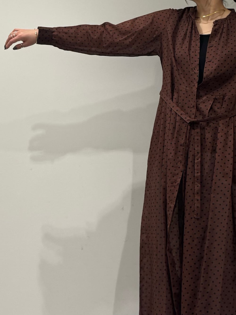 ブラウン系のワンピース、ブルー系のデニムパンツ、ブラック系のローファーを着用したレディースの春コーディネートの7枚目の写真