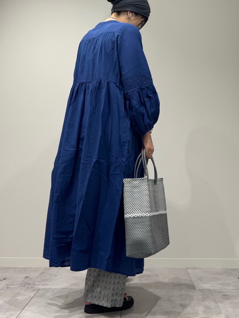 シルバー系のかごバッグ、ブラック系のサンダル、ベージュ系のその他パンツを着用したレディースの春コーディネートの3枚目の写真