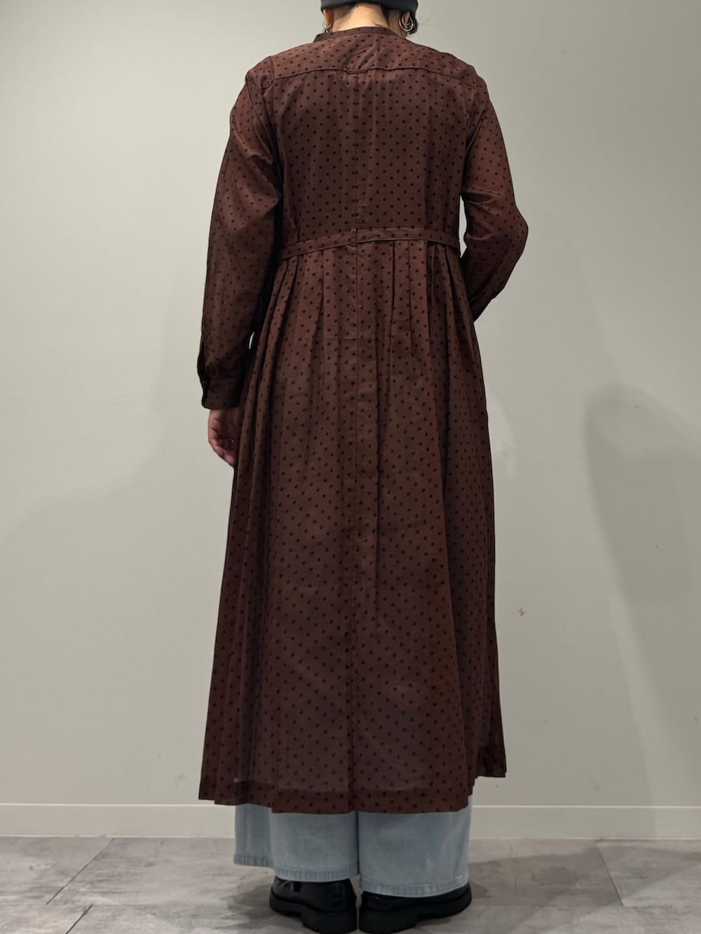 ブラウン系のワンピース、ブルー系のデニムパンツ、ブラック系のローファーを着用したレディースの春コーディネートの4枚目の写真