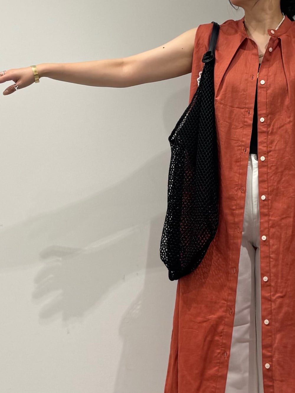 レッド系のワンピース、ホワイト系のデニムパンツ、ブラック系のサンダルを着用したレディースの夏コーディネートの5枚目の写真