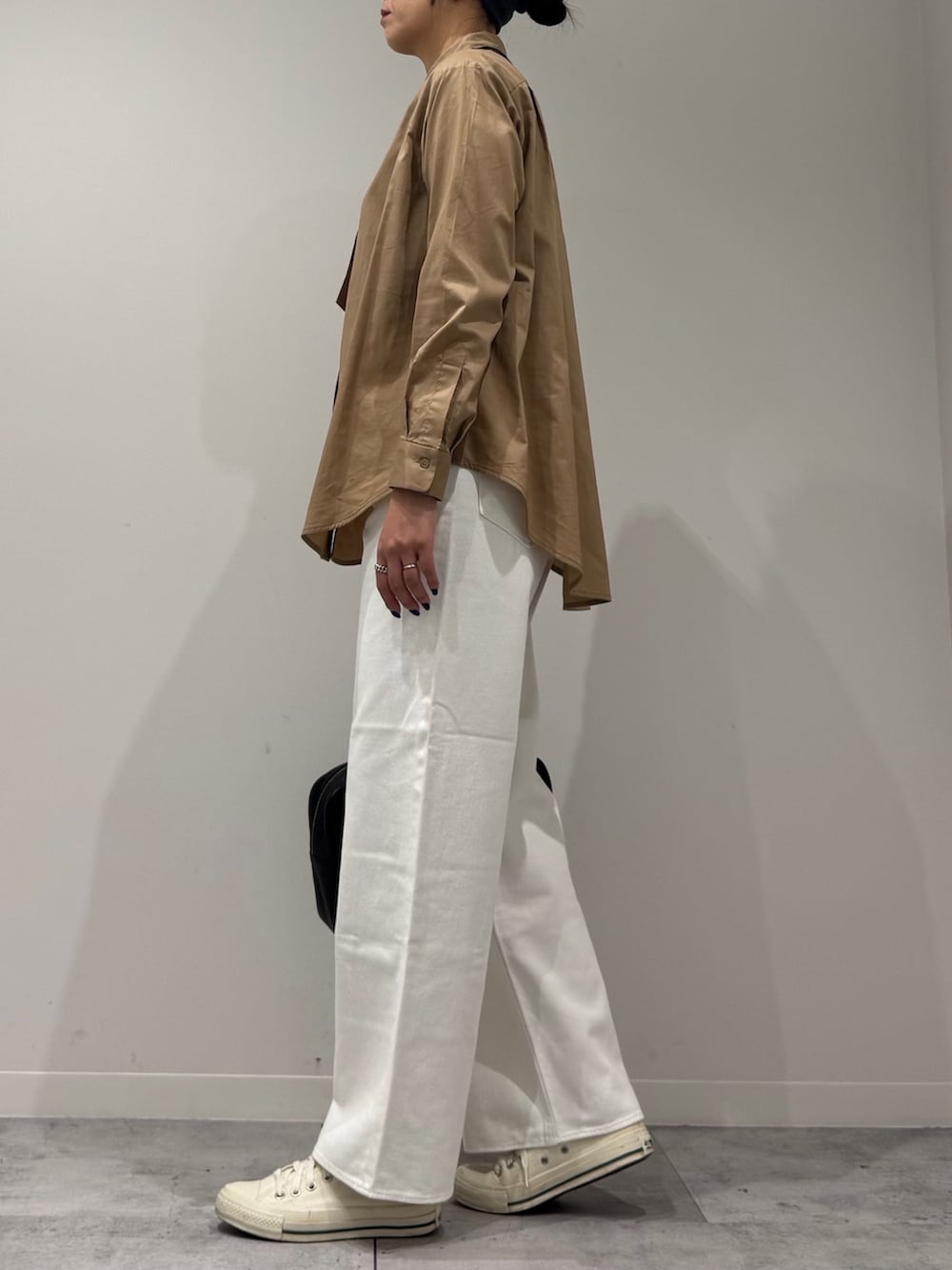 ベージュ系のシャツ/ブラウス、ホワイト系のデニムパンツ、ブラック系のボストンバッグを着用したレディースの秋コーディネートの6枚目の写真