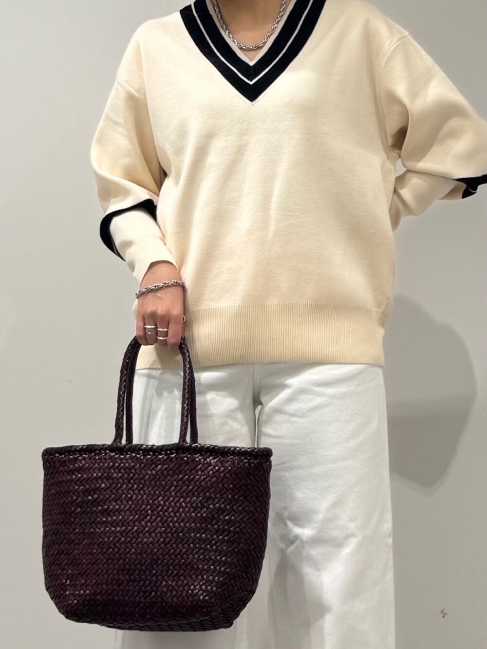 パープル系のトートバッグ、ホワイト系のデニムパンツ、ブラック系のローファーを着用したレディースの冬コーディネートの7枚目の写真