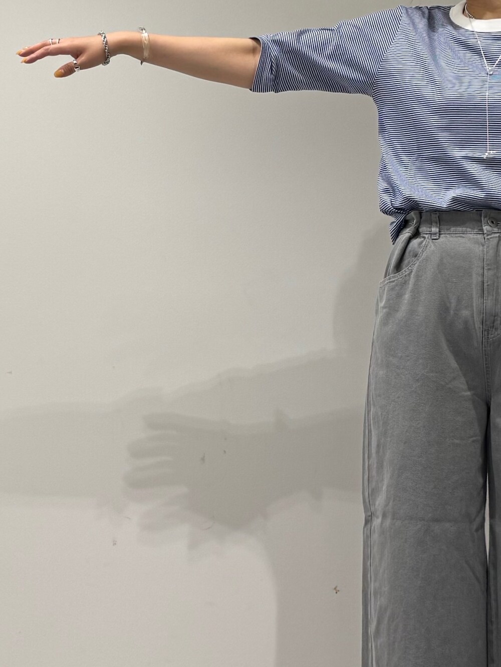 ホワイト系のトートバッグ、グレー系のデニムパンツ、ブラック系のサンダルを着用したレディースの夏コーディネートの7枚目の写真