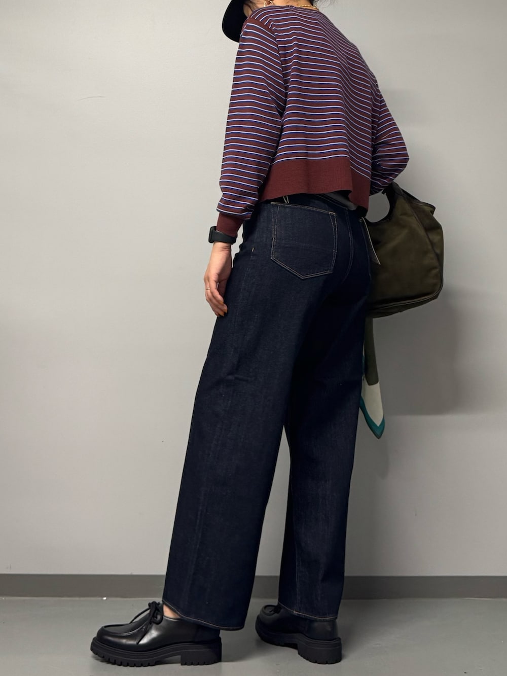 ブラック系のパンプス、ブルー系のデニムパンツ、レッド系のカーディガン/ボレロを着用したレディースの秋コーディネートの5枚目の写真