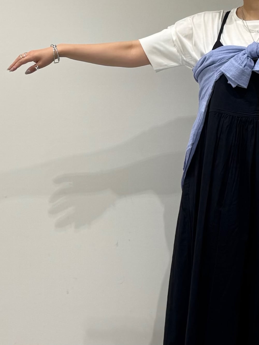 ベージュ系のかごバッグ、ブラック系のワンピース、ブラック系のサンダルを着用したレディースの夏コーディネートの6枚目の写真