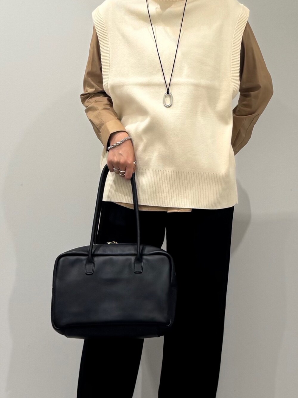 ブラック系のその他パンツ、ホワイト系のベスト、ベージュ系のシャツ/ブラウスを着用したレディースの秋コーディネートの7枚目の写真