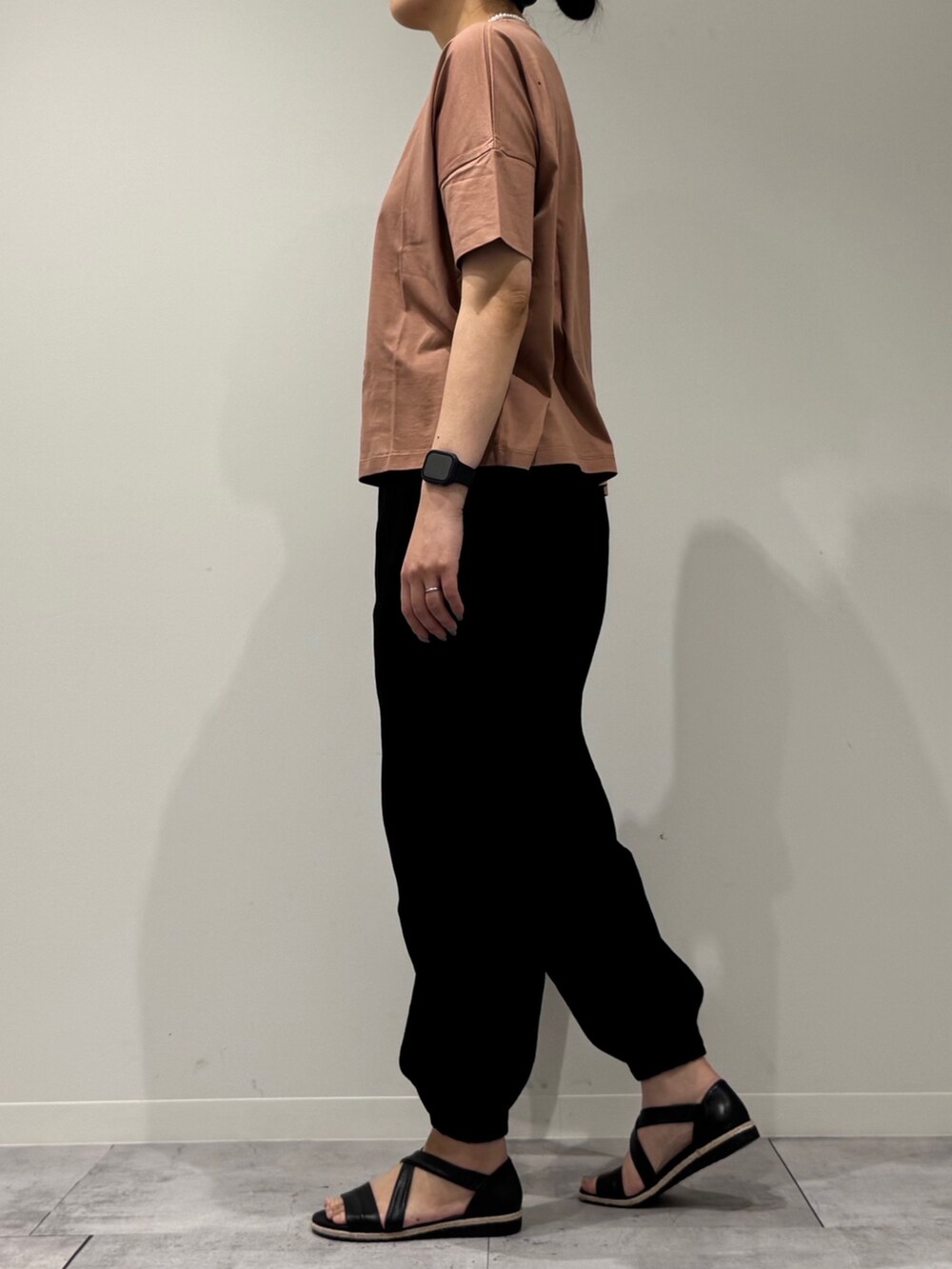 シルバー系のかごバッグ、ブラック系のサンダル、ゴールド系のネックレスを着用したレディースの春コーディネートの6枚目の写真