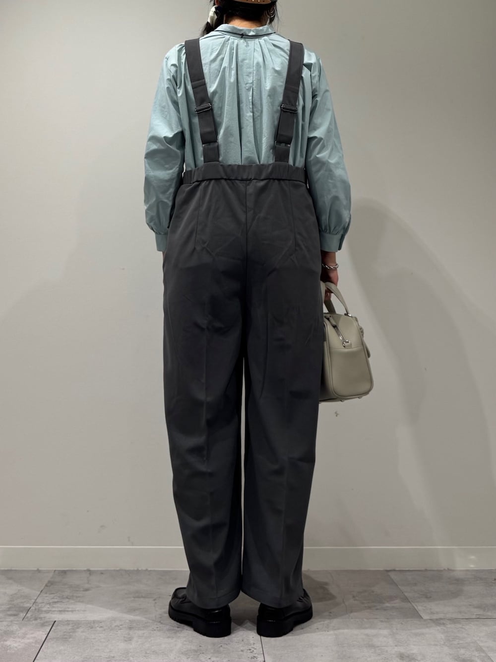 ブラック系のローファー、グレー系のサロペット/オーバーオール、グレー系のボストンバッグを着用したレディースの秋コーディネートの3枚目の写真