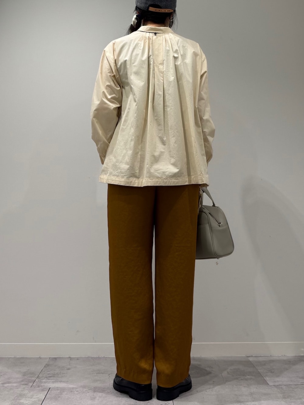 グレー系のボストンバッグ、ホワイト系のシャツ/ブラウス、ブラウン系のその他パンツを着用したレディースの秋コーディネートの3枚目の写真