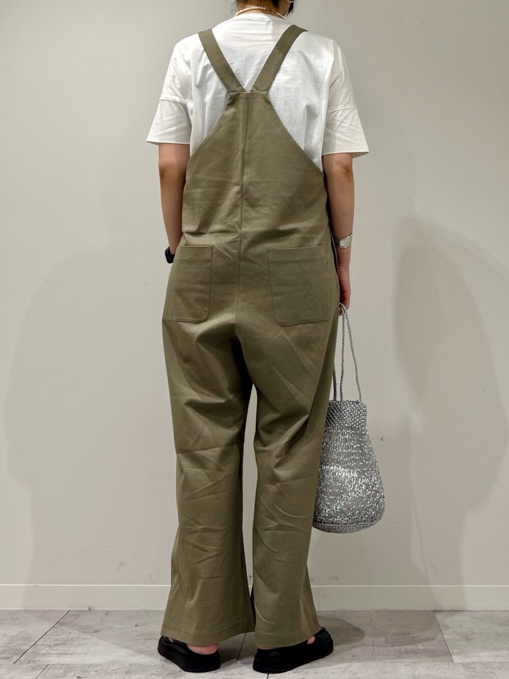 シルバー系のかごバッグ、ブラック系のサンダル、ホワイト系のTシャツ/カットソーを着用したレディースの夏コーディネートの4枚目の写真