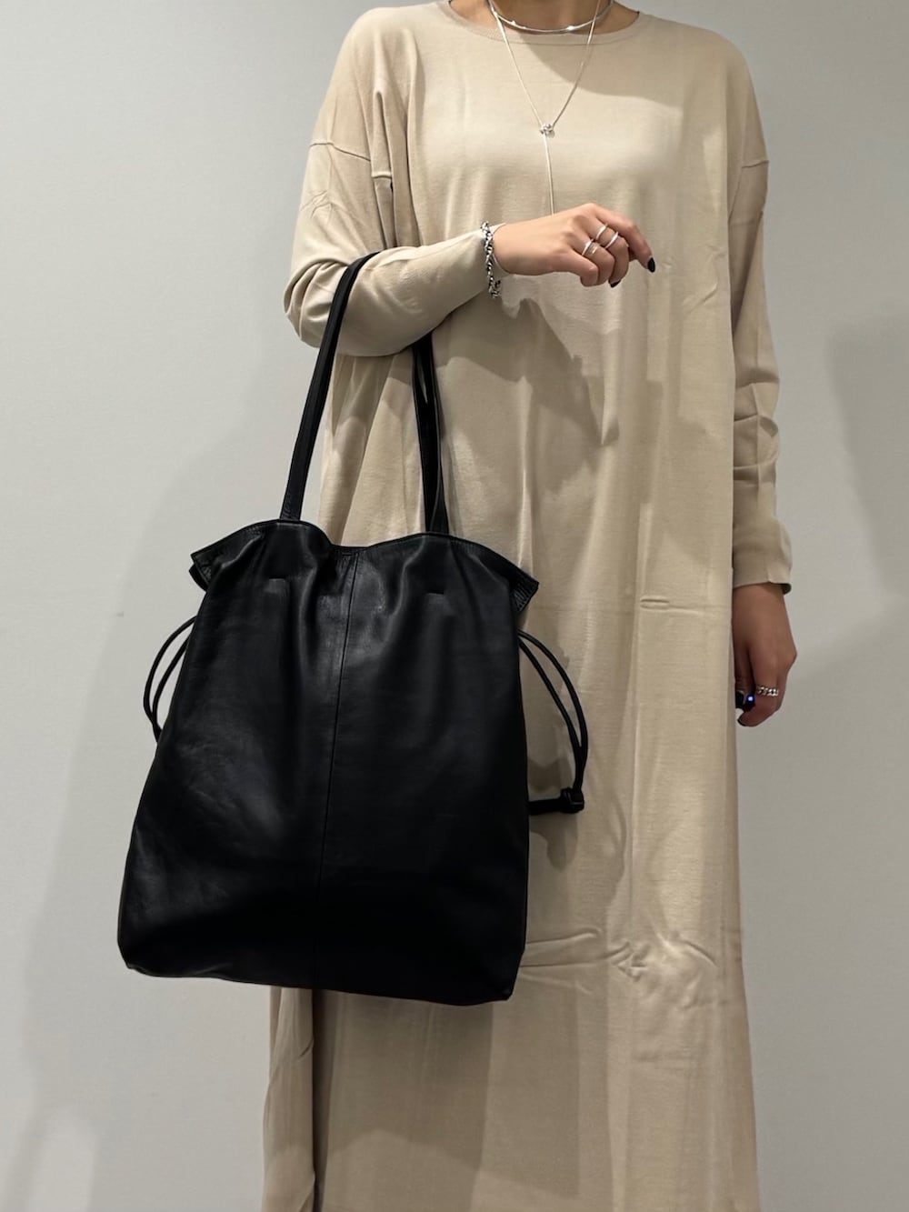 ベージュ系のワンピース、ブラック系のローファー、ブルー系のデニムパンツを着用したレディースの冬コーディネートの7枚目の写真